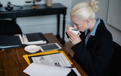 Femme buvant du café à un bureau avec des documents