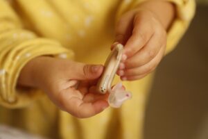 Un enfant tient un appareil auditif et son petit embout en main
