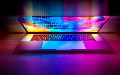 Un ordinateur portable ouvert projette des couleurs vives sur le clavier
