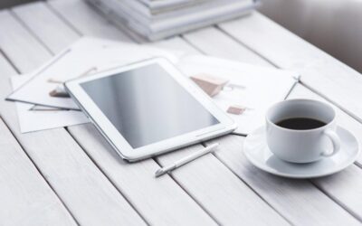 Tablette blanche, stylus, tasse de café sur saucer, documents sur table blanche