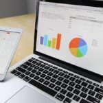 Un ordinateur portable et une tablette affichent des graphiques sur un bureau
