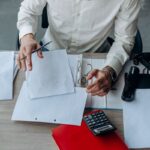 Un homme en chemise blanche examine des documents sur un bureau