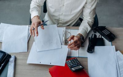 Un homme en chemise blanche examine des documents sur un bureau